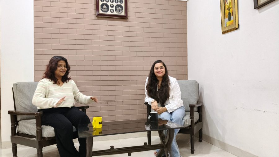 Two people seated in armchairs mid-conversation